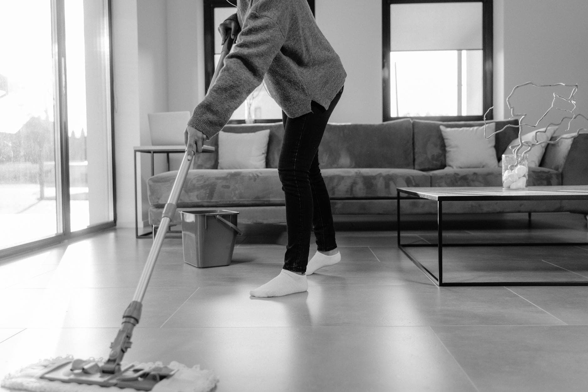 Professional New Jersey cleaner mopping the floor in a modern apartment living room — Regular Apartment Cleaning in Edison, Central Jersey